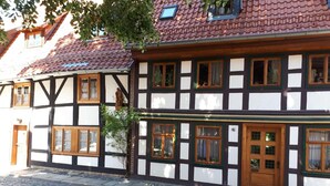 A traditional half-timbered building with a cobblestone street in front. - Ferienwohnung Nahe Wernigerode (Wernigerode)