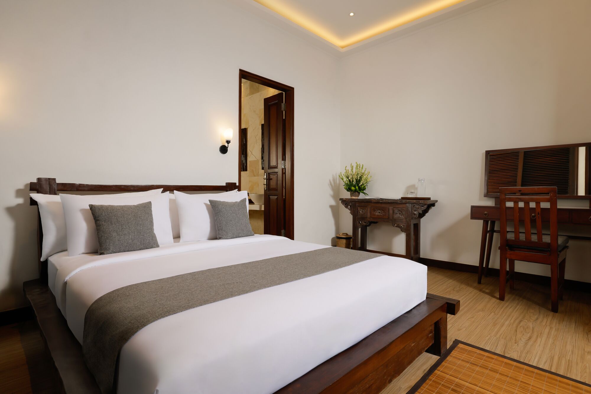 Een netjes ingerichte slaapkamer met een groot bed, een bureau en een stoel.