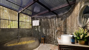 Uma casa de banho com uma banheira grande, uma pia e um espelho.