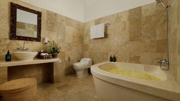A bathroom with a freestanding bathtub, a sink, a toilet, and a shower.