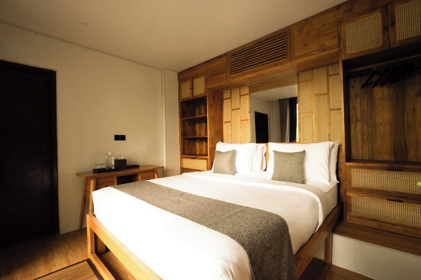 Un dormitorio con una cama grande, cabecera de madera y una mesita de noche con lámpara.
