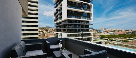 A balcony with outdoor furniture and a city view.