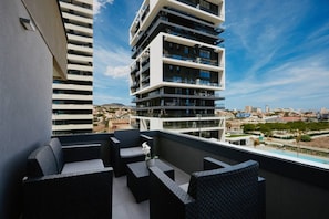 Un balcón con mobiliario exterior y vistas a la ciudad.