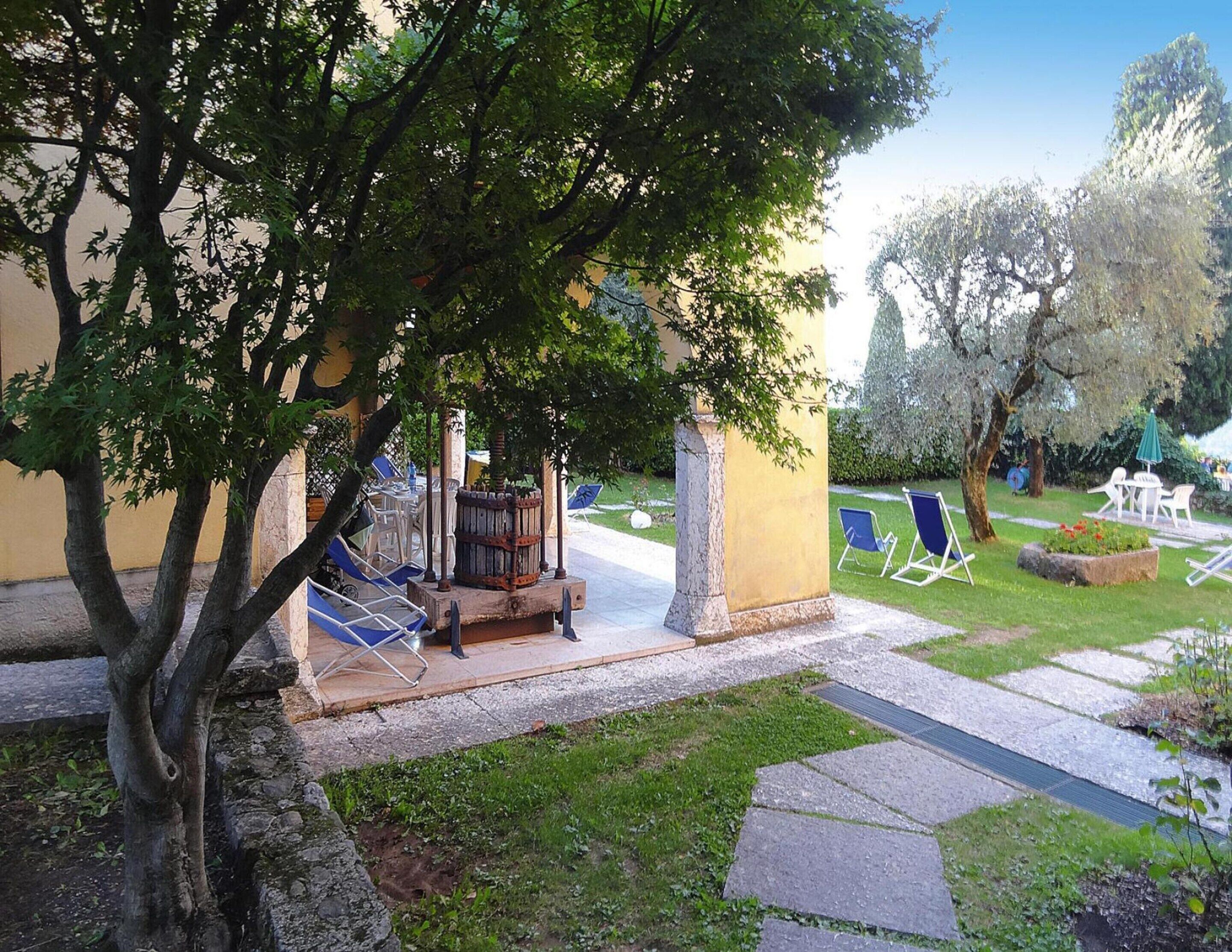 Ein Innenhof mit Brunnen, Liegestühlen und einer Pergola, die Schatten spendet.