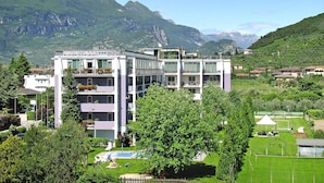 A multi-story hotel with balconies, a swimming pool, and a view of mountains. - Apartment in Riva del Garda (Riva del Garda)