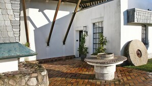 A courtyard with a stone bench, a large stone wheel, and a potted plant. - Detached Holiday Home in Medelby (Medelby)
