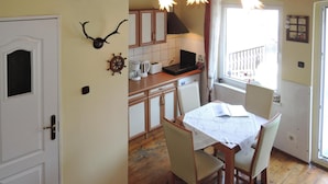 Une cuisine de taille réduite avec des meubles en bois, une table à manger avec des chaises et une vue sur un balcon par le biais d’une fenêtre.
