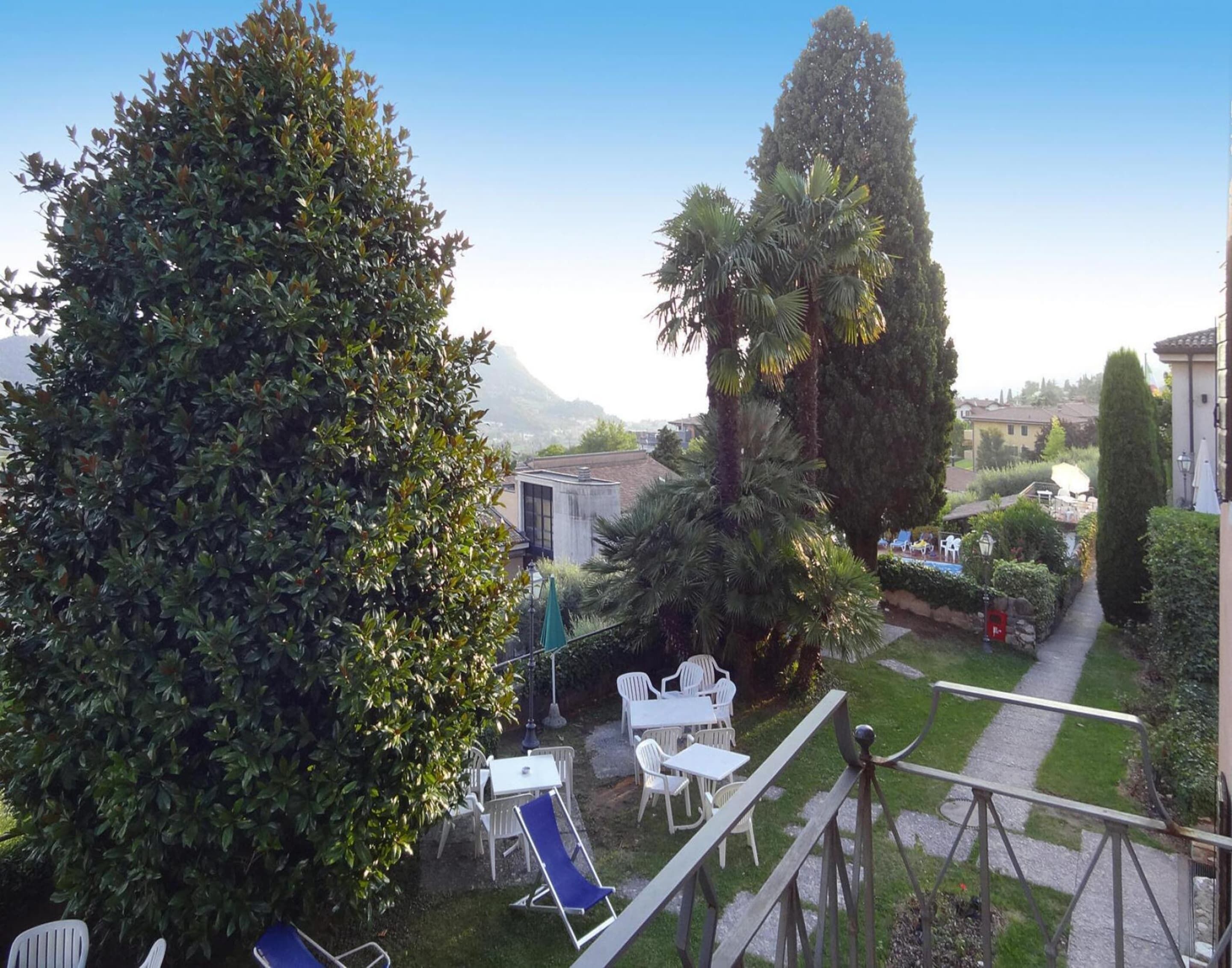 A garden with a patio area featuring outdoor furniture, a pathway, and a view of the surrounding landscape.