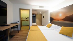 A hotel room with a bed, a desk, and a kitchenette. - Apartment in Riva del Garda (Riva del Garda)
