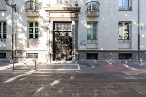 Un edificio con una puerta de entrada grande y ornamentada, varias ventanas y balcones.