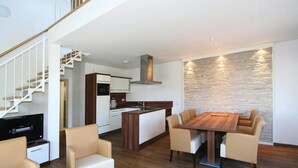 A modern apartment with a dining area, kitchen, and living room. - Appartement in Cuxhaven (Cuxhaven)