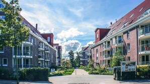 A residential street with brick buildings, balconies, and a clear sky. - Appartement in Cuxhaven (Cuxhaven)