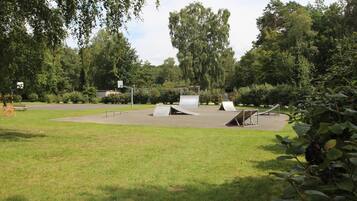 A park with a playground area featuring metal ramps and a slide.