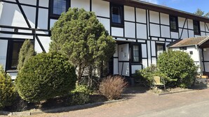 A traditional half-timbered building with a symmetrical facade, multiple windows, and a small porch area. - Gemutliche Ferienwohnung in Fassberg (Faßberg)