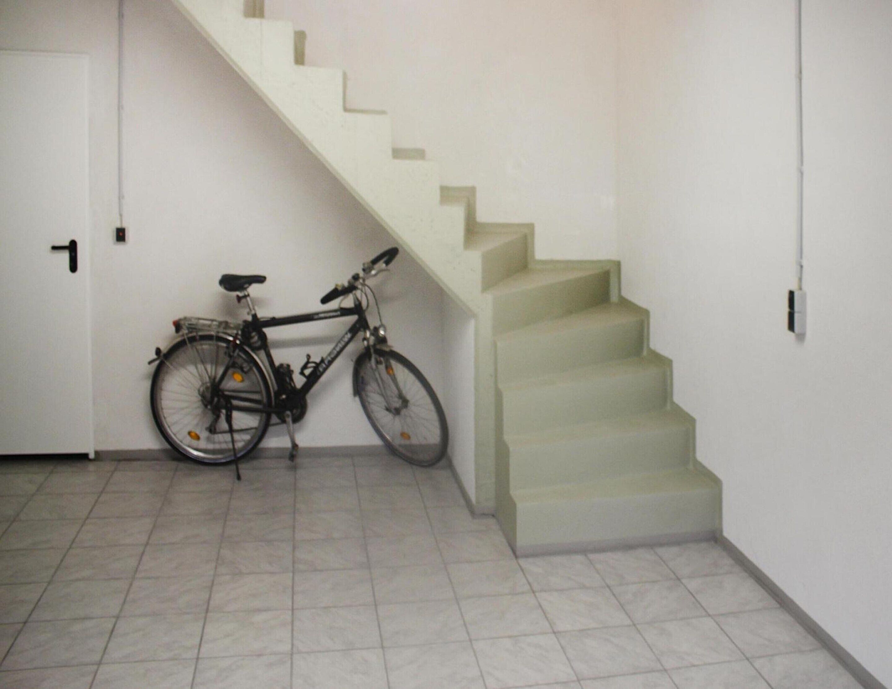 A staircase with a bicycle parked against the wall.