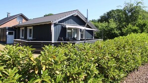 Une maison moderne dotée d’un porche abrité, d’une antenne parabolique et d’une cheminée.