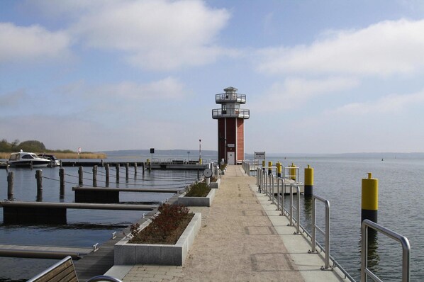 A lighthouse at the end of a pier with a clear sky. - Appartement Hafenflair am Plauer See (Plau am See)