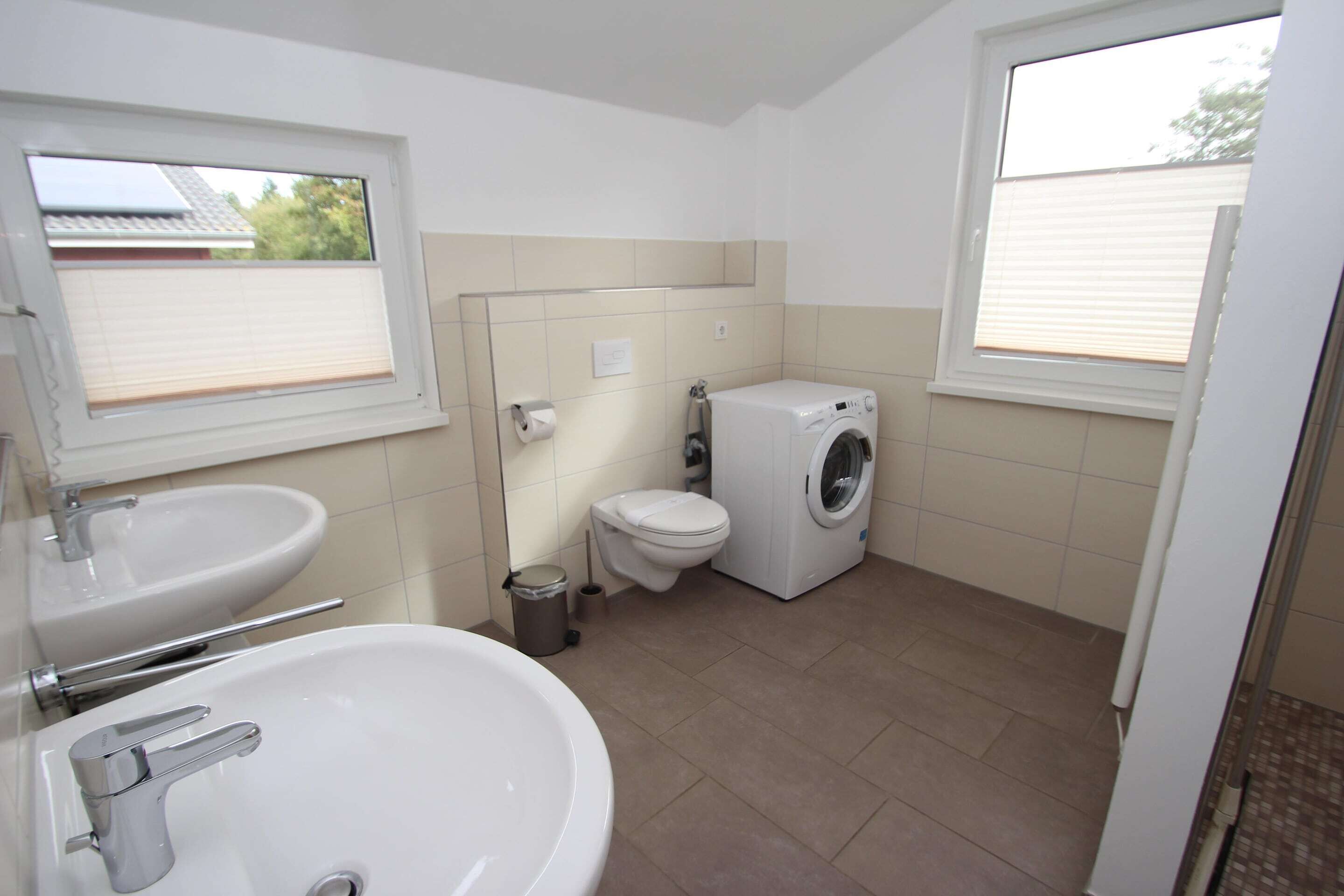 Ein Badezimmer mit Waschbecken, Toilette und Waschmaschine.