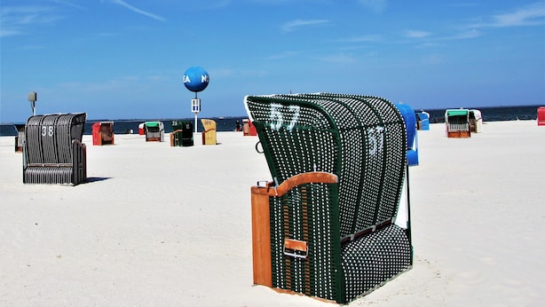 A beach with several beach chairs and a blue beach ball. - Ferienhaus, Dornumersiel (Dornum)