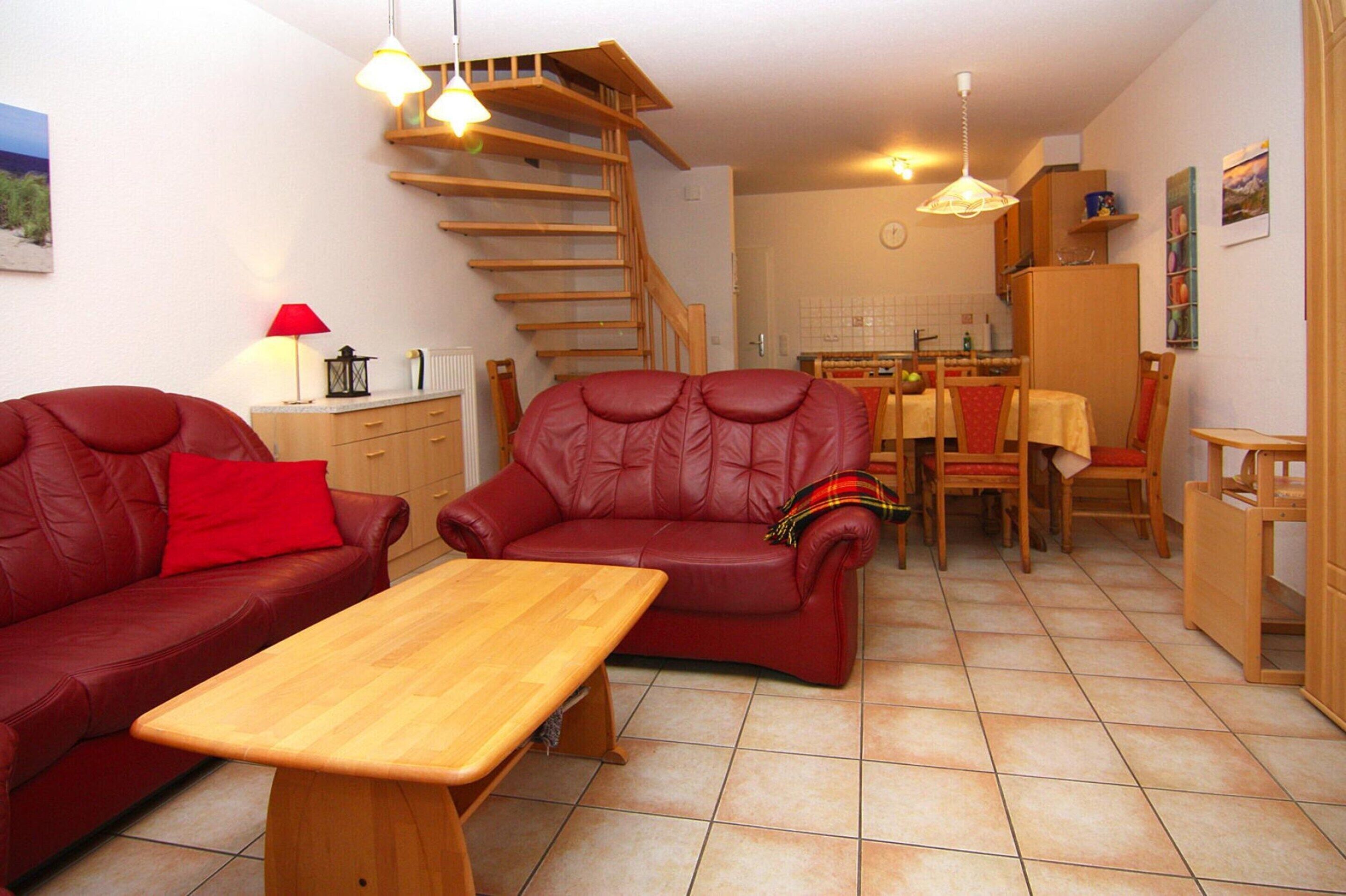 A compact living space with a sofa, a dining table, and a staircase.