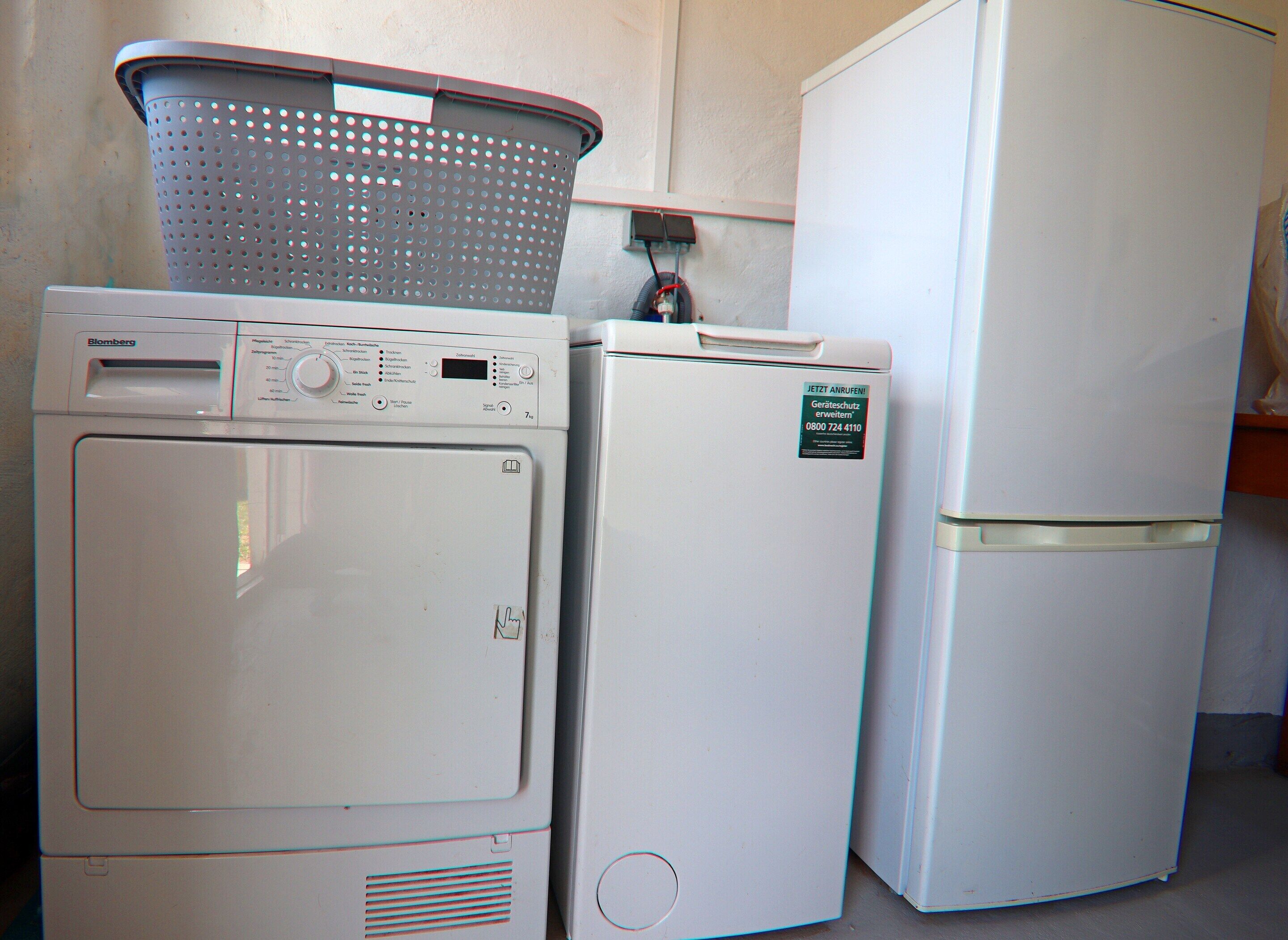 A white washing machine and refrigerator in a kitchen.