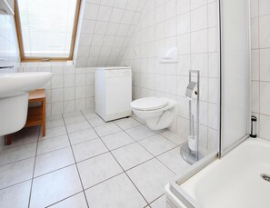 Une salle de bain moderne équipée de toilettes, d’un lavabo et d’une douche.