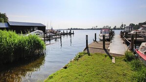 Um lago tranquilo com um píer, barcos e um pequeno edifício com telhado azul.