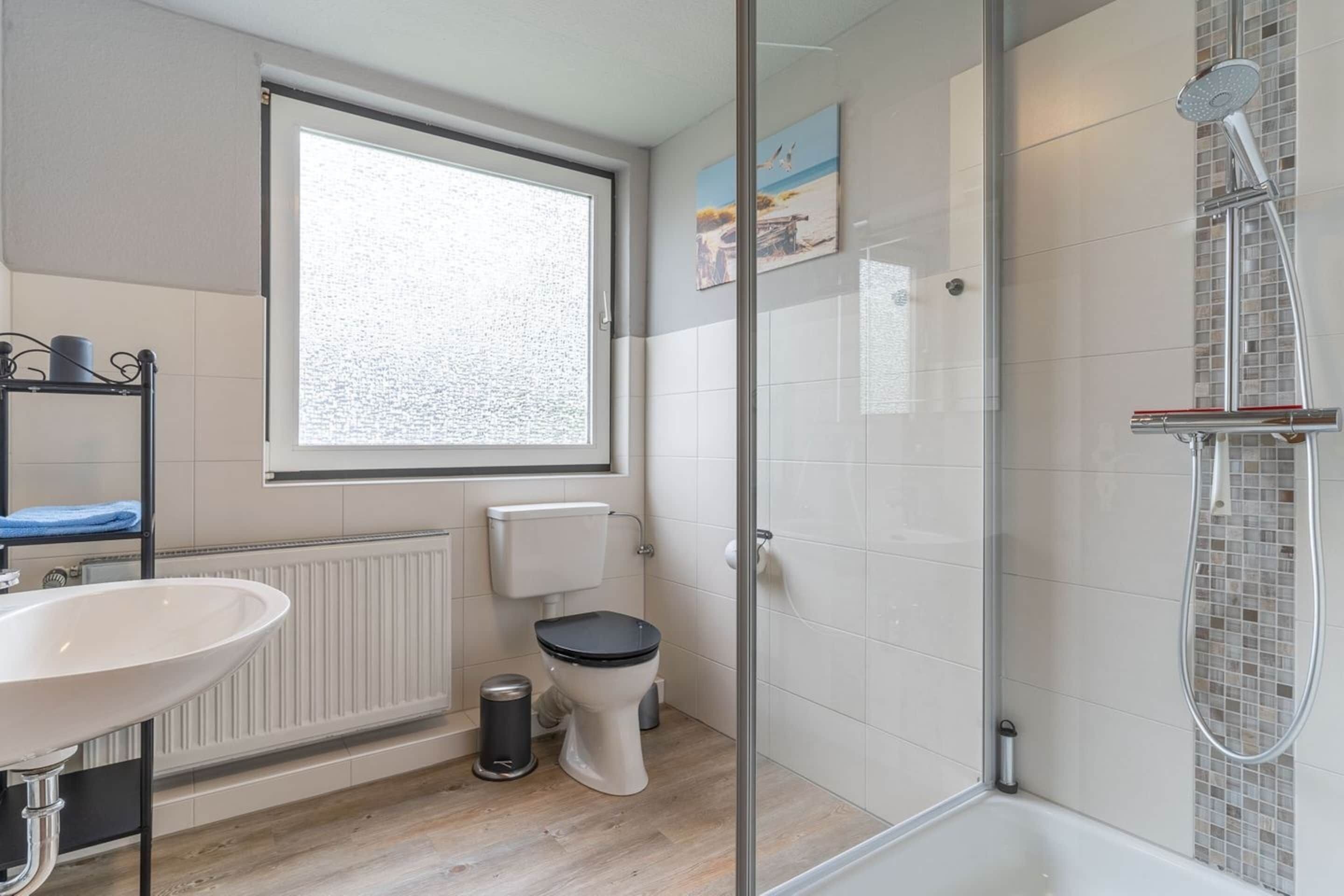 Un bagno moderno con il water, un lavandino e una doccia.