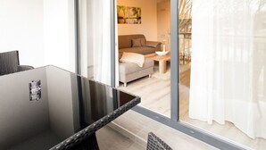 A modern living room with a glass door leading to a balcony. - Appartements mit Blick auf die Spree in Lubben (Lübben (Spreewald))