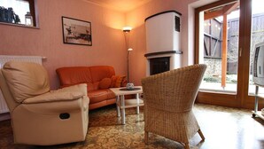 A cozy living room with a sofa, a chair, a small table, and a fireplace.