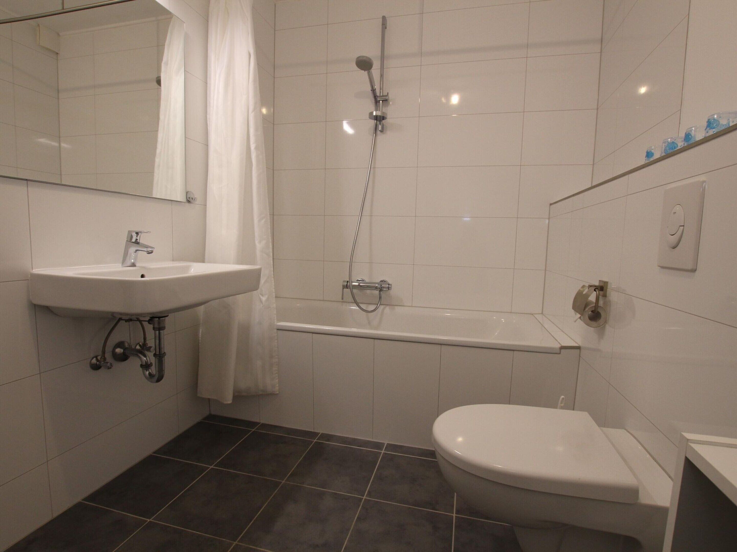 Un baño con lavabo, inodoro y ducha.