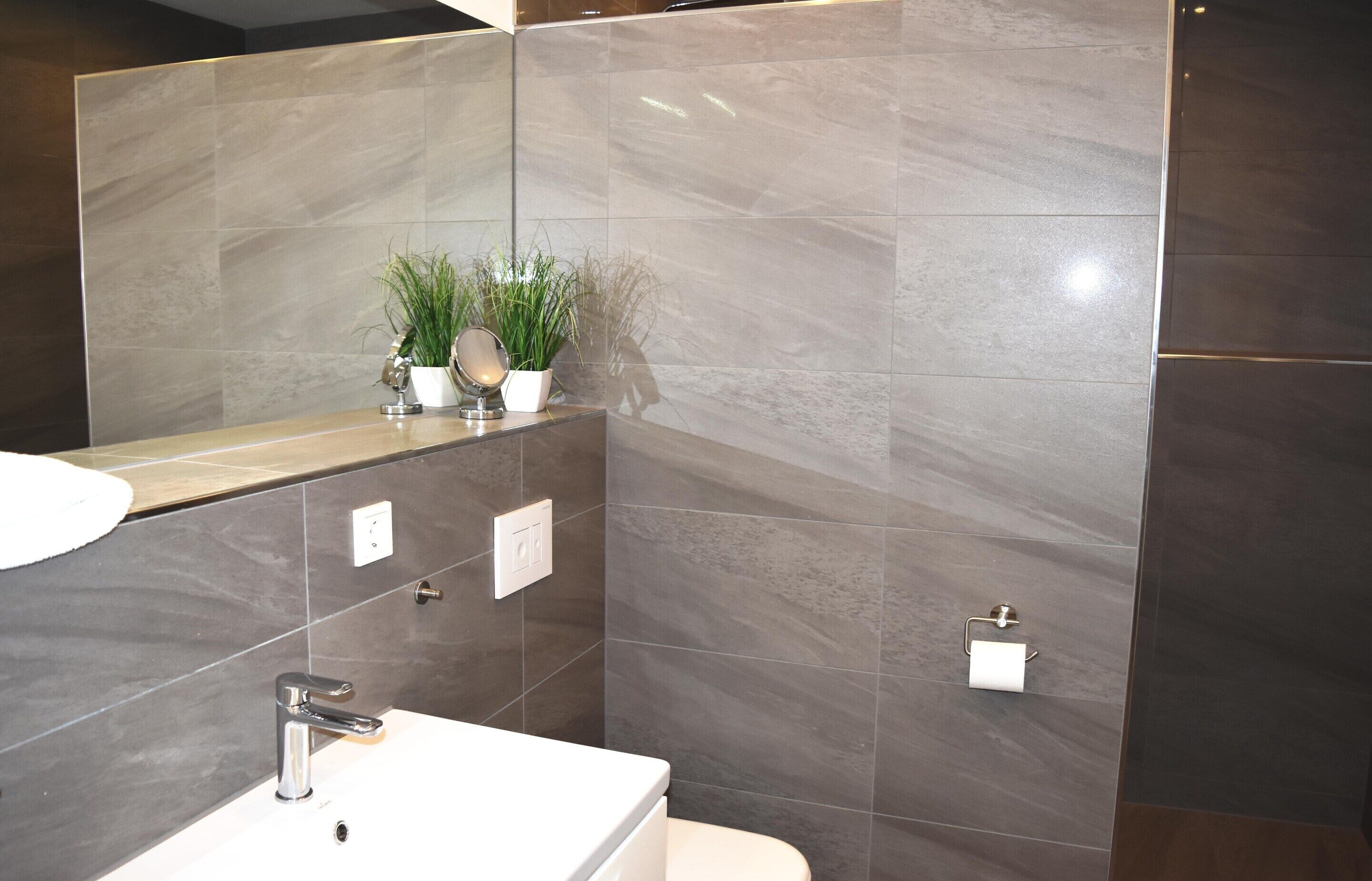 Ein Badezimmer mit Waschbecken, Spiegel und Toilette.