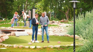 A golf course with a putting green, surrounded by rocks and greenery. - Appartements im Freizeitpark Weissenhauser Strand (Wangels)