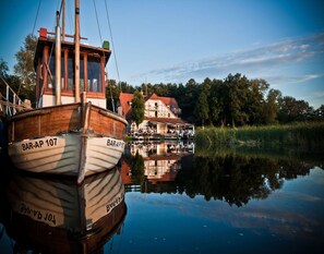 A wooden boat named BAR-AP 107 docked near a house with a reflection in the water. - Ferienhaus Bel Ami, Nakenstorf (Zurow)