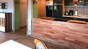 Una cocina compacta con encimera de madera, microondas y refrigerador.