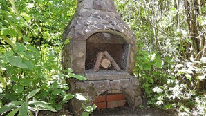 A stone-built outdoor oven surrounded by dense greenery. - Ferienhaus in Dornhan (Dornhan)
