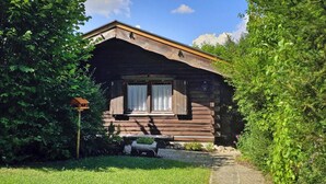 A rustic log cabin with a sloped roof, a small porch, and a bird feeder. - Ferienhaus in Dornhan (Dornhan)
