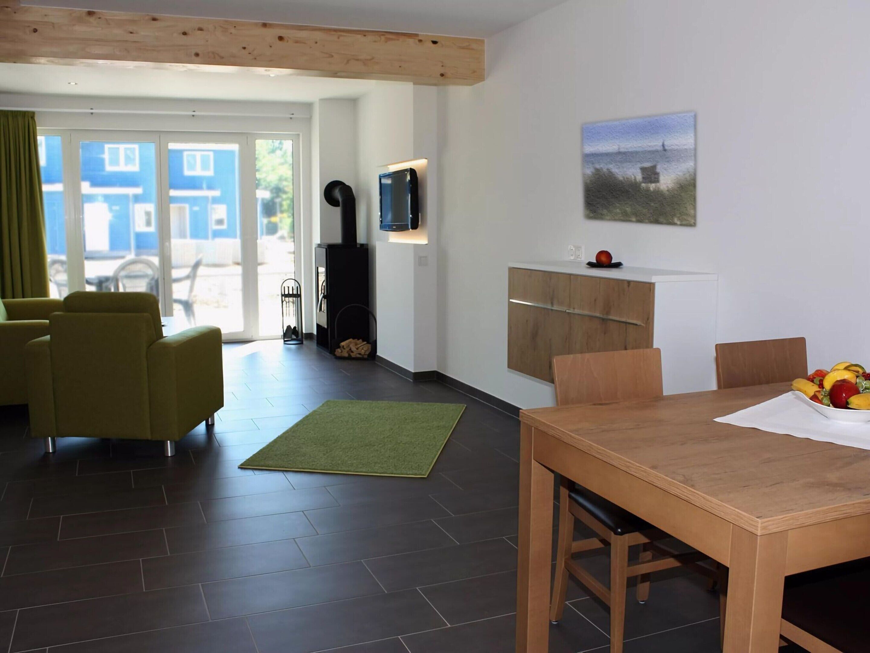 Ein modernes Wohnzimmer mit einer Couch, einem Esstisch und einem Fernseher.