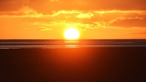 Ein Sonnenuntergang über dem Meer bei klarem Himmel.