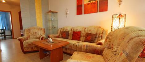 A living room with a sofa set, a coffee table, and a glass cabinet.