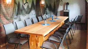 A long wooden table with chairs, a mural on the wall, and a fireplace. - Ferienwohnung an der Elde (Luebz)