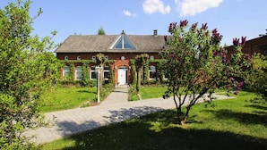 A traditional brick house with a tiled roof, a central gable, and a front door. - Ferienwohnung an der Elde (Luebz)