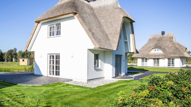 A white house with a thatched roof and a smaller attached structure. - Haus an der Bodden-lagune mit Sauna (Fuhlendorf)