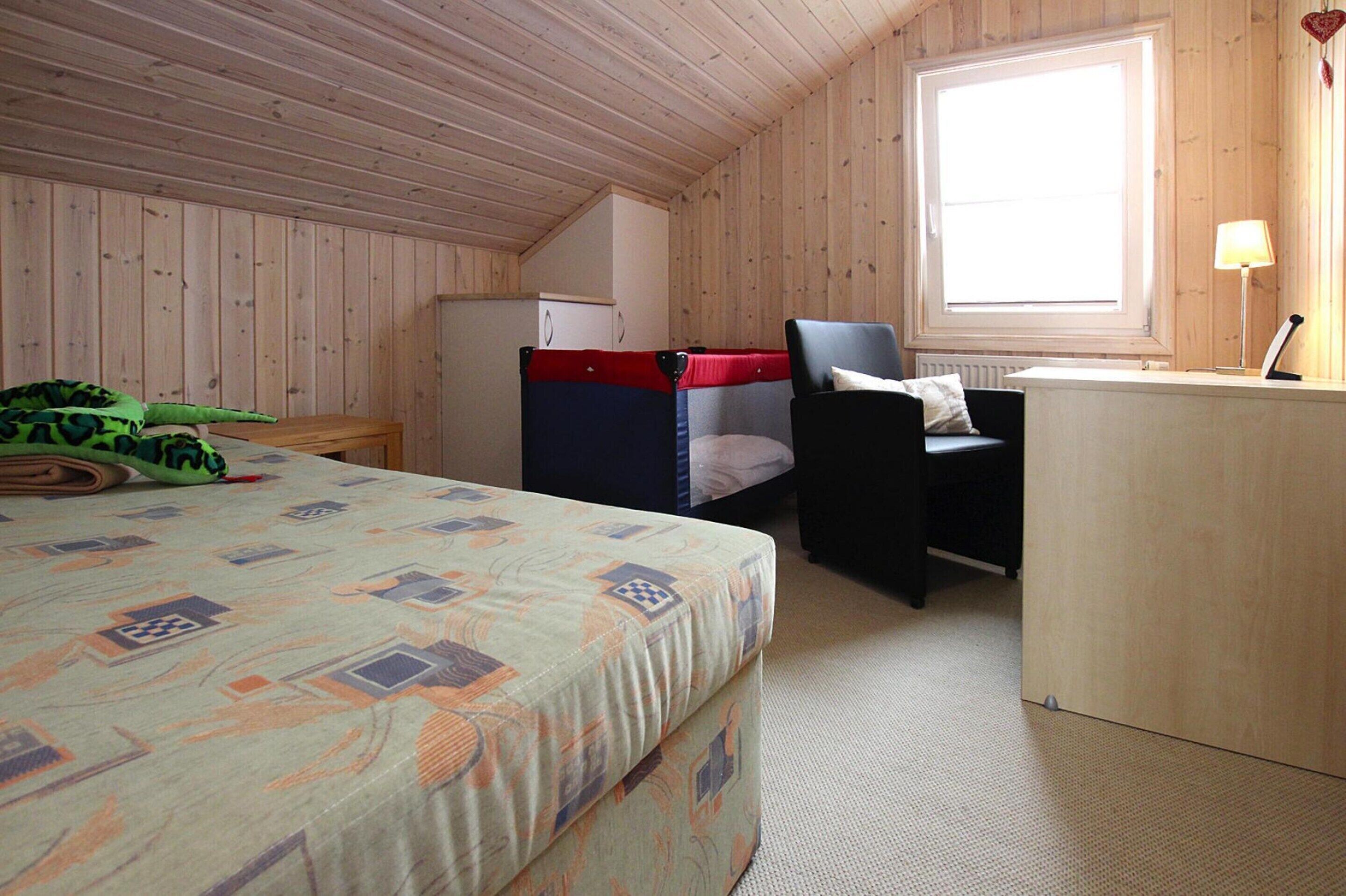 Una habitación con una cama, un escritorio y una silla.