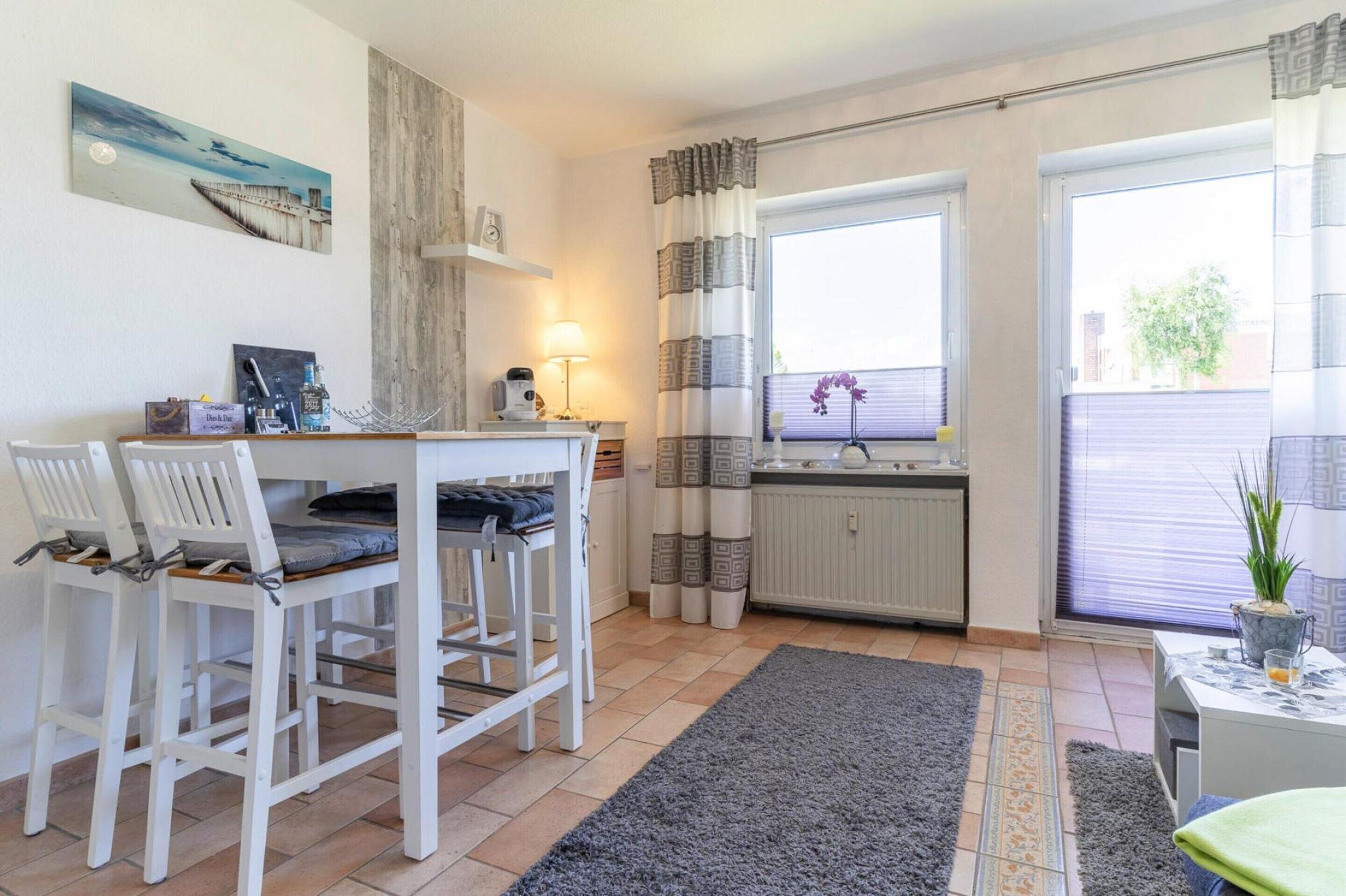 Eine kleine Küche mit Essbereich, einem Heizkörper und einem fensterbepflanzten Fenster.