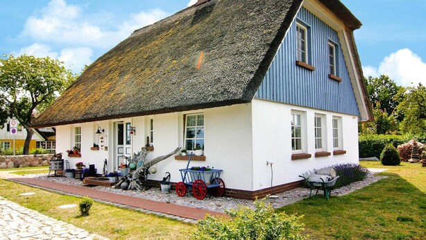 A traditional house with a steep thatched roof, white walls, and a blue upper section. - Ferienwohnung, Wieck am Darss (Wieck auf dem Darss)