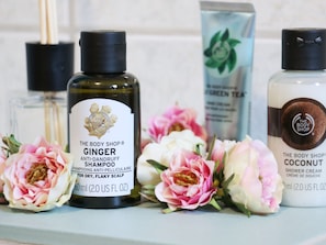 Three bottles of body shop products: ginger shampoo, green tea, and coconut shower cream. - Appartement im Fuchsbau in Bad Sachsa (Bad Sachsa)