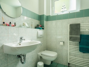 A bathroom with a sink, toilet, and towel rack. - Appartement im Fuchsbau in Bad Sachsa (Bad Sachsa)