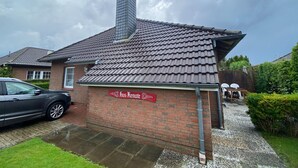 Un bâtiment en briques avec un toit en tuiles, une cheminée et une enseigne sur laquelle on peut lire « Hus Rente ».