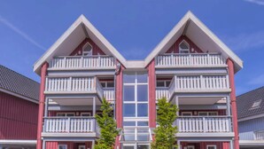 A red and white two-story building with balconies and a central entrance. - Apartment in Rechin Right on the Water (Rechlin)